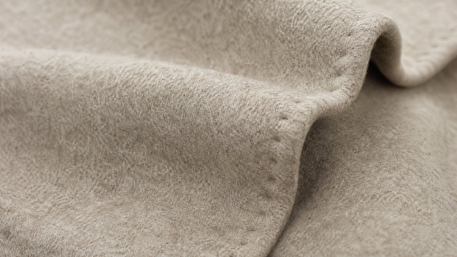 Close detail of overlapping charcoal ribbed and oatmeal cable knitted fabric