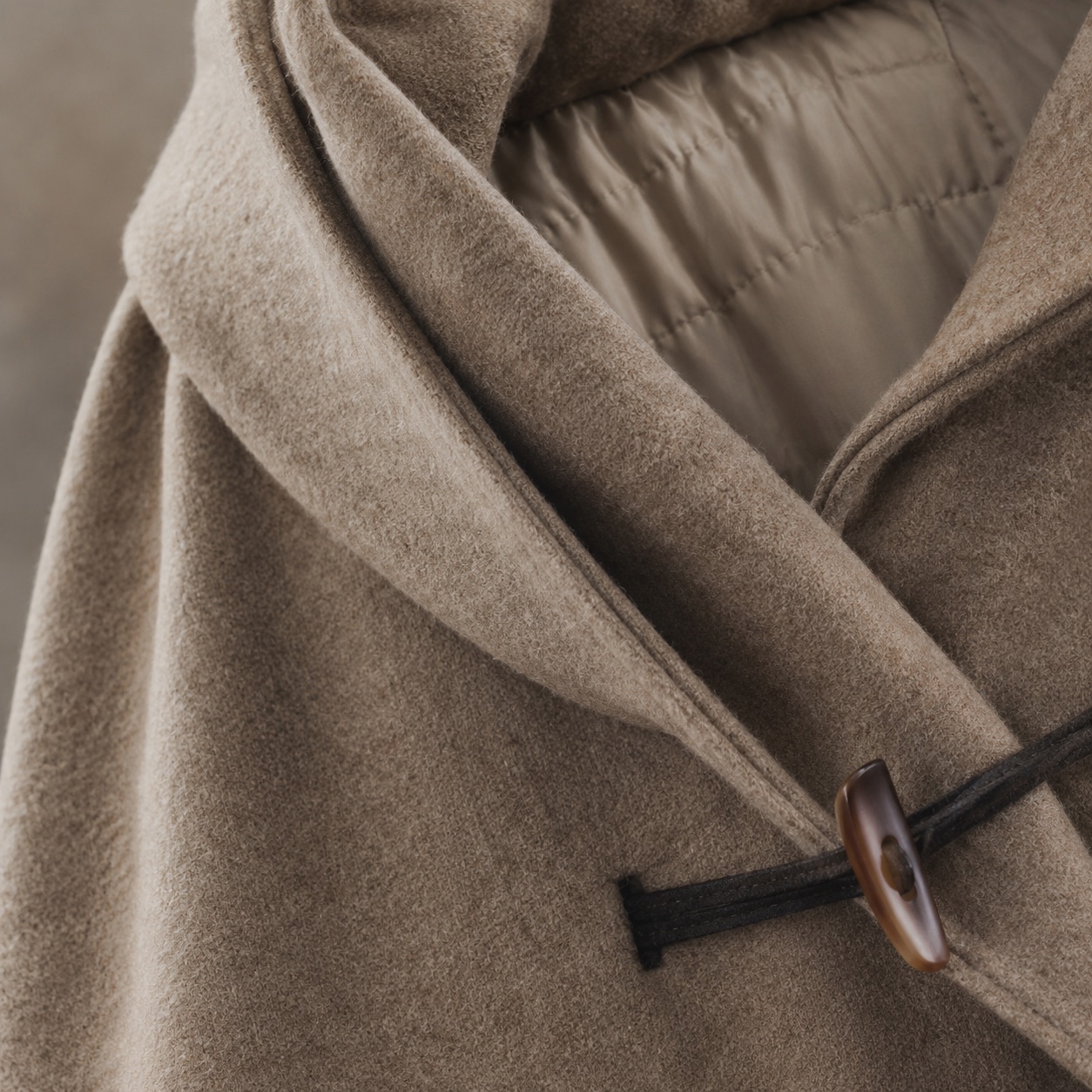 Fernhollow hooded wool cape — Down & Cape Outerwear by MASO. close detail of the fabric and finish.