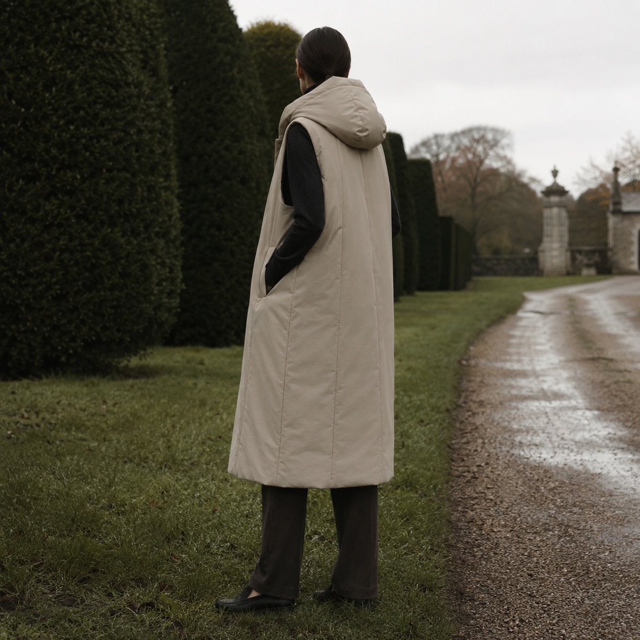 Mossgate hooded down gilet coat — Down & Cape Outerwear by MASO. worn by a model, side view.