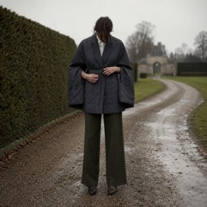 Cotswold wool cape with arm slits — Down & Cape Outerwear by MASO. worn by a model.