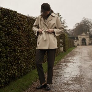 Windrush short raglan trench — Trench Coats by MASO. worn by a model.