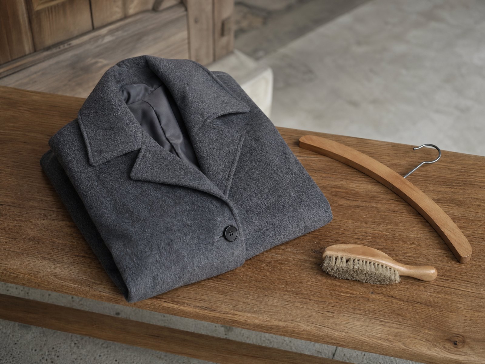 A folded lambswool jumper beside wool detergent flakes and a garment brush